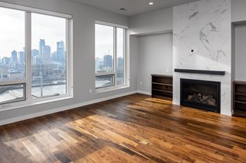 A living room with a fireplace and a view of the city